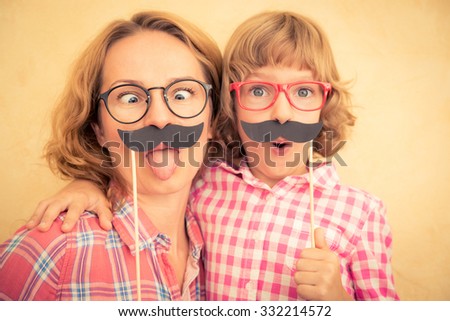 Mother and child with fake mustache. Happy family playing in home  Royalty-Free Stock Photo #332214572