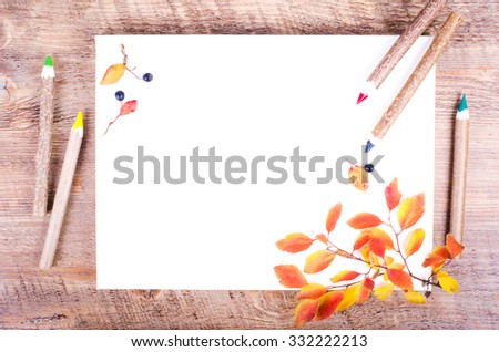 Colorful autumn leaves and pensils lying on diary, notebook, paper, wooden background. Fall and thanksgiving. Autumn composition. Free space for text.