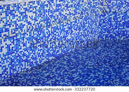 Blue modern blue background bottom of a swimming pool. Small glass tiles lined with rows of white tiles Venetian mosaic