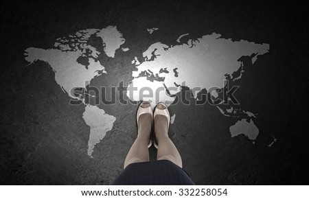 Top view of businesswoman feet and world map on floor