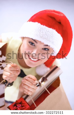 Happy girl on santa hat with gift box on red background