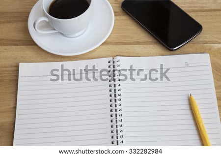 Notepad, smartphone, pen and cup of coffee on wood table - Work office supplies 