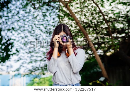 Happy young Asian girl using a film camera