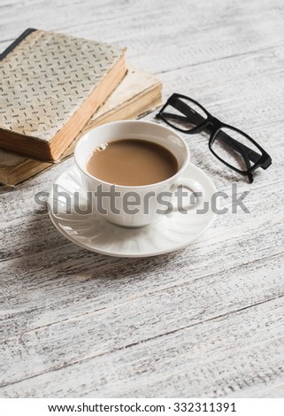 Books, glasses and coffee cup on bright wooden surface