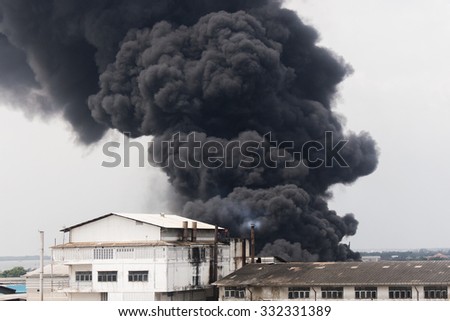Fire burning and black smoke over the Factory. Royalty-Free Stock Photo #332331389