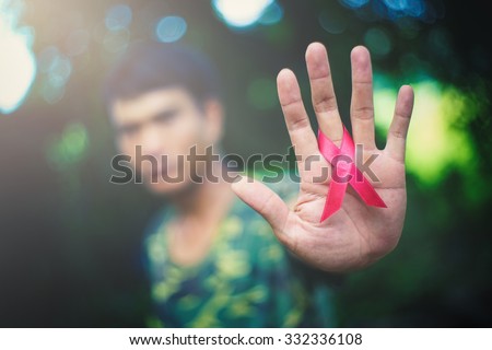 red aids ribbon in hand. Royalty-Free Stock Photo #332336108