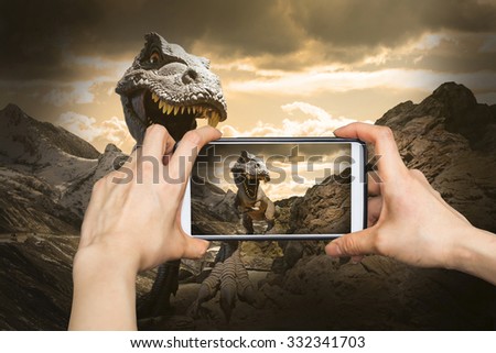 Taking pictures on mobile smart phone in Dinosaurs model on rock mountain 