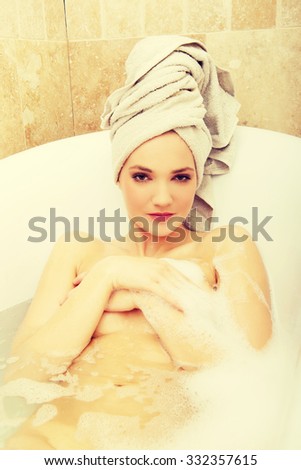 Young spa woman relaxing in bathtub. 