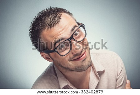 Funny man looking to you. Nerd guy with eyeglasses watching, Dark gray background. Studio shot