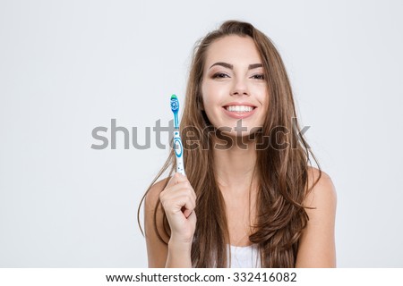 Portrait of a smiling cute woman holding toothbrush isolated on a white background Royalty-Free Stock Photo #332416082