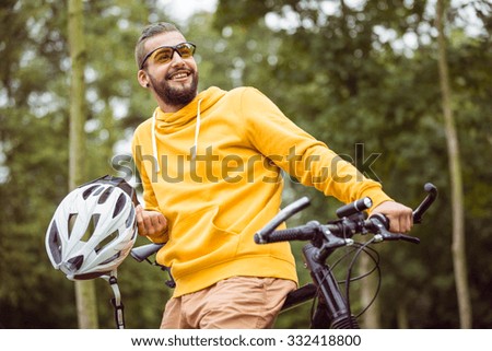 Handsome man with mountain bike in the countryside