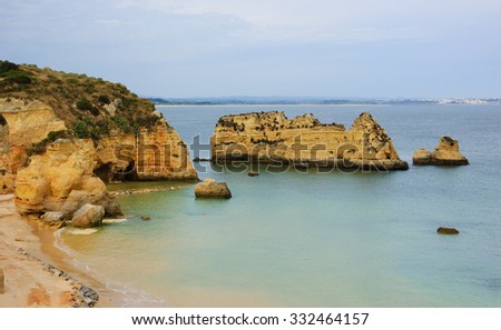 Stone arches, caves, rock formations at Dona Ana Beach (Lagos, Algarve coast, Portugal) in the evening light. 