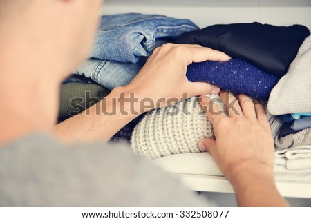 closeup of a young caucasian man arranging the closet