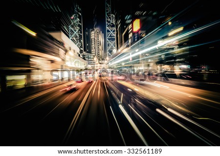 Abstract cityscape traffic background with motion blur, art toning. Moving through modern city street with  illuminated skyscrapers. Hong Kong Royalty-Free Stock Photo #332561189