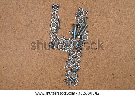 Four from bolts and nuts. Photo of mozaic sign on wood background.