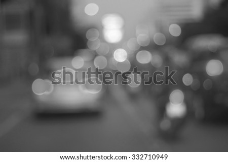A black and white bokeh background Blurred street light. Evening traffic. Motion blur.