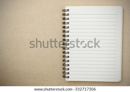 Half open note book on brown paper background, vignette effect.