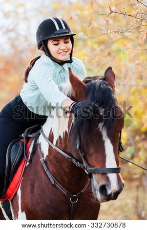 Rider on brown horse. Beautiful girl with horse outdoors Royalty-Free Stock Photo #332730878