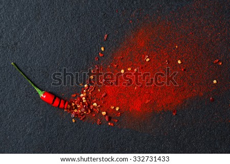 Chilli, red pepper flakes and chilli powder burst Royalty-Free Stock Photo #332731433