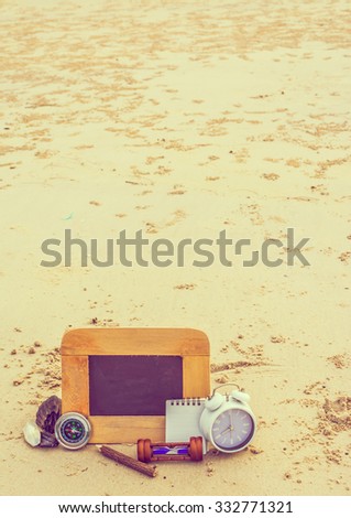 journey concept vintage tone image of chalkboard and stationery items For creative idea with blur sea in background.(selective focus on chalkboard)