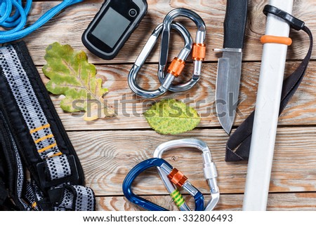 Equipment for mountaineering and hiking on wooden background. Tourism background.