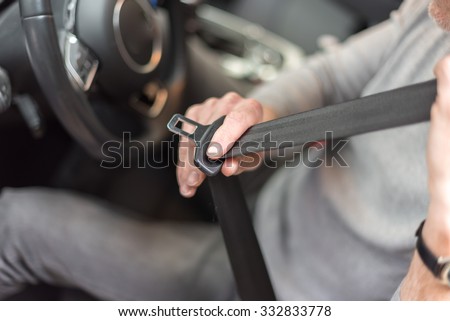 Man fastening seat belt in car Royalty-Free Stock Photo #332833778