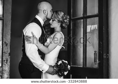 The bride and groom in a cozy house, photo taken with natural light from the window.