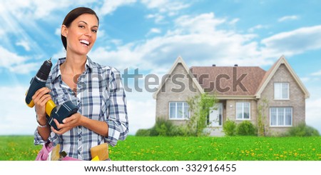 Young woman with a drill. House renovation background.