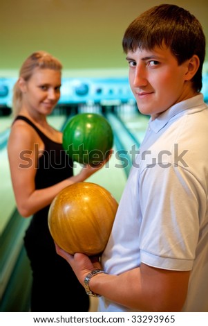 Pretty couple with two color bowling balls