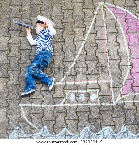 Cute little boy sailing on ship or boat picture drawing with chalk. Creative leisure for children outdoors in summer