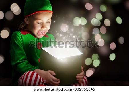 Cute little girl opening a magic gift box.