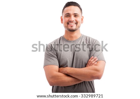 Handsome Latin athlete in a sporty outfit with his arms crossed and smiling on a white background