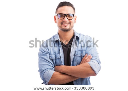 Latin hipster guy wearing glasses with his arms crossed and smiling on a white background Royalty-Free Stock Photo #333000893