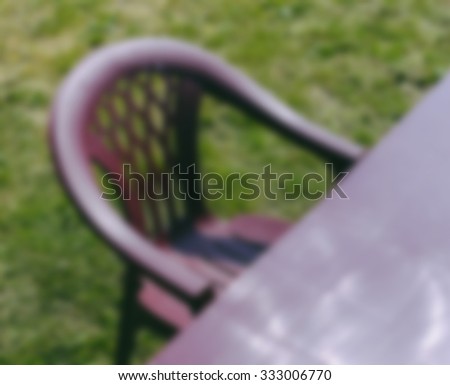 Blurred defocused background photo of the chair on green grass