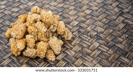 Dried white mulberry over wicker background