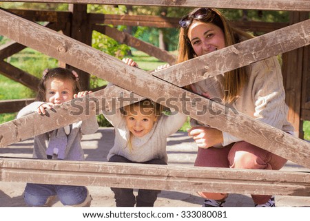 Happy mother with two daughters relaxing in the park.Family lifestyle, autumn season.