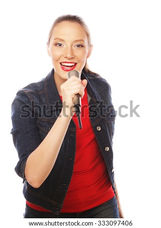 Happy singing girl. Beauty woman wearing red t-shirt  with microphone over white background. 