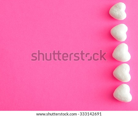 Valentine's Day. A row of white polystyrene hearts on a pink background