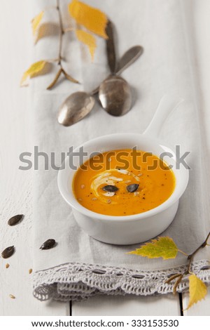 Spicy pumpkin and carrot soup with cream, pumpkin and line seeds.