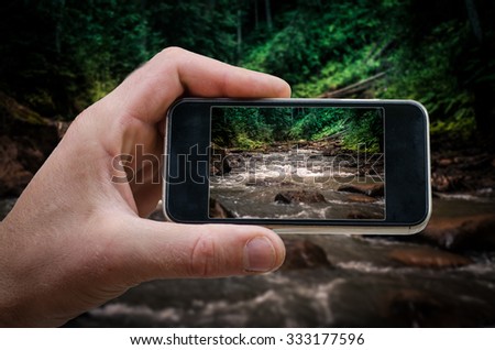 phone in hand man (photographing the landscape) mountain river
