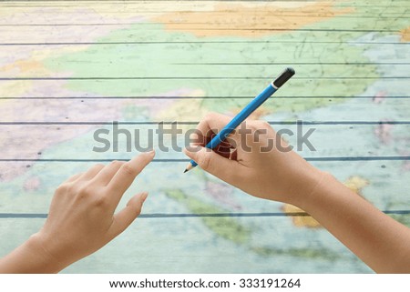 hand holding pencil on blur map floor