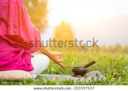 Tibetan bell beside yoga position in a meadow the sun Royalty-Free Stock Photo #333197537