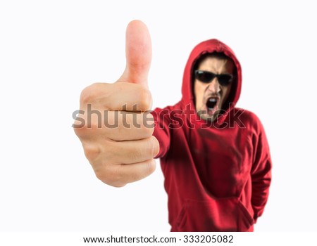 portrait of a casual man with sweatshirt and sunglasses is making a gesture with the thumb up and screaming