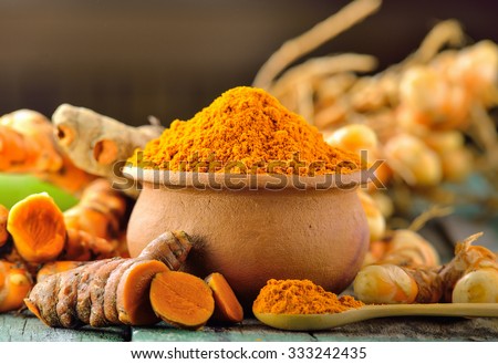 turmeric roots on wooden table Royalty-Free Stock Photo #333242435