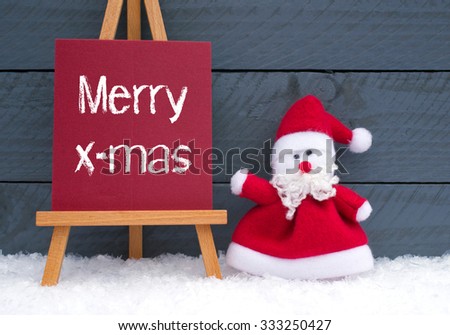 Merry Christmas - Santa Claus with sign and text on wooden background with snow