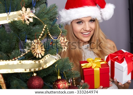 christmas, x-mas, winter, happiness concept, smiling woman in santa helper hat with many gift boxes