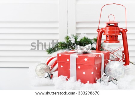 Christmas decorations with gift box, red vintage lantern and fir tree on white wooden background