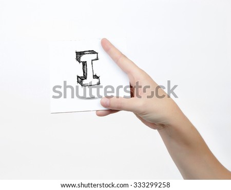 Hand holding a piece of paper with sketchy capital letter I, isolated on white.