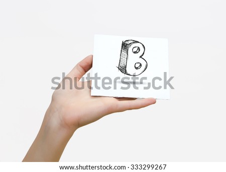 Hand holding a piece of paper with sketchy capital letter B, isolated on white.
