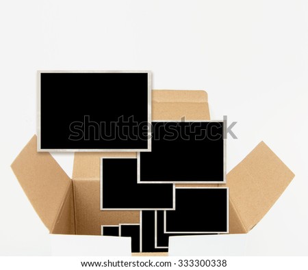 Opened carton box with old photograph templates, isolated on white.